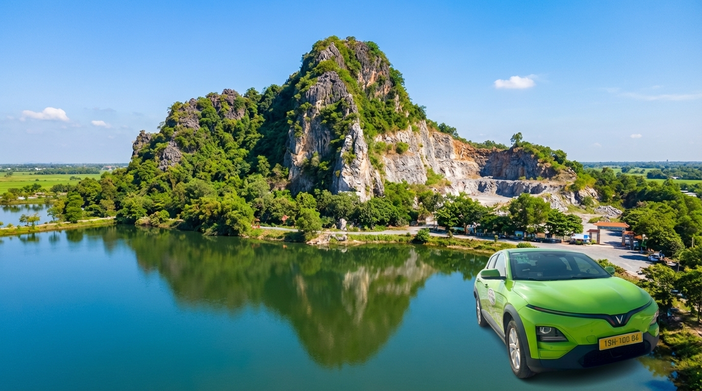 Núi Sập Thoại Sơn với hồ nước xanh dưới chân núi và taxi VinFast VF6 đậu ở khu du lịch
